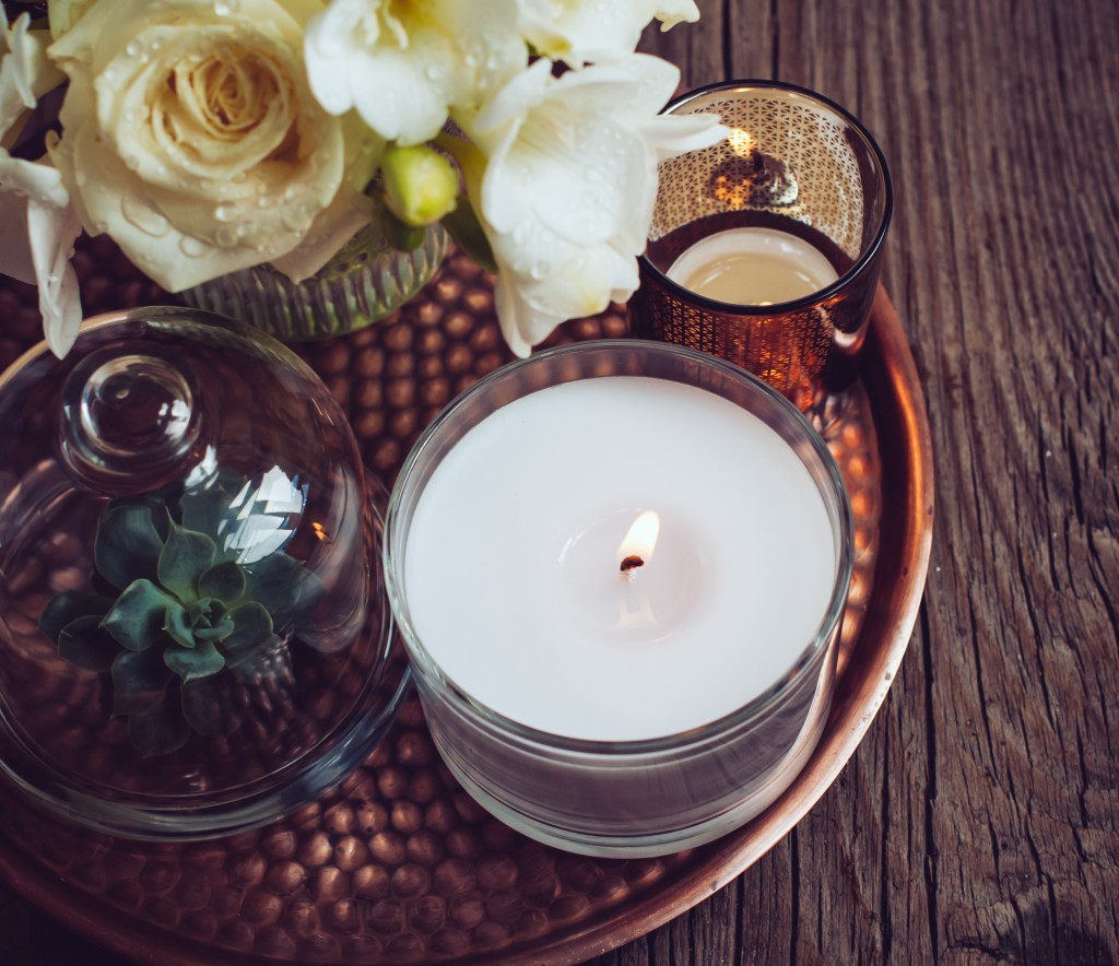 lit candles on tray with white flowers